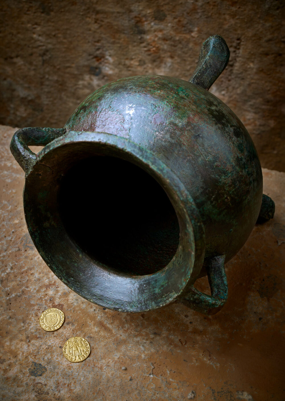 Bronzenes Kochgefäß mit zwei Goldmünzen