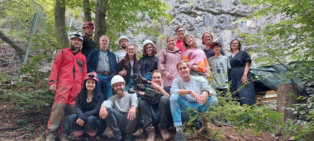 Das Gruppenfoto zeigt das Team der LWL-Archäologie, Stella und das Kamerateam und entstand am Ende des Tages vor der Blätterhöhle in Hagen.