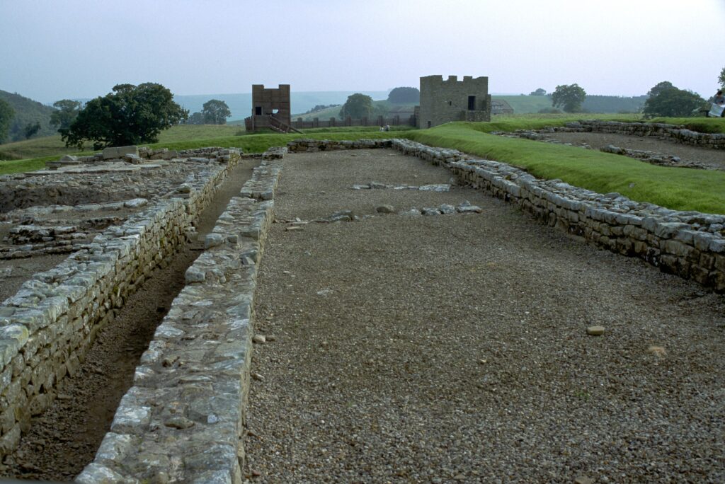 Aufnahme von Vindolanda, Standort einer römischen Militärsiedlung am Hadrianswall. Im Hintergrund ist das rekonstruierte Kastell aus dem 3. Jahrhundert zu sehen. 